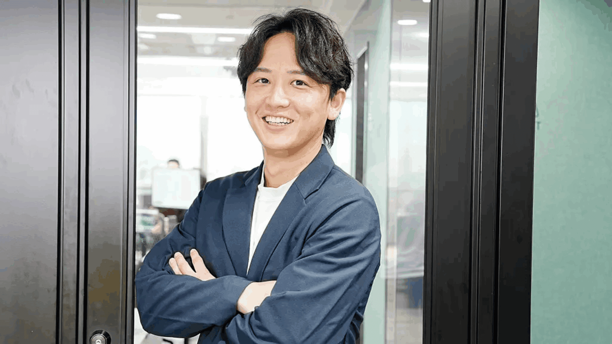 DigiManのCEO、足立明則氏が同社の東京オフィスに立っている